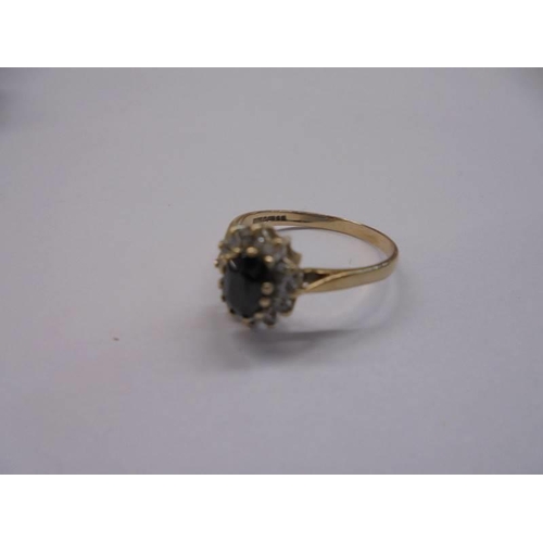 1082 - A sapphire cluster ring set with white stones in gold band, size L, 1.5 grams.