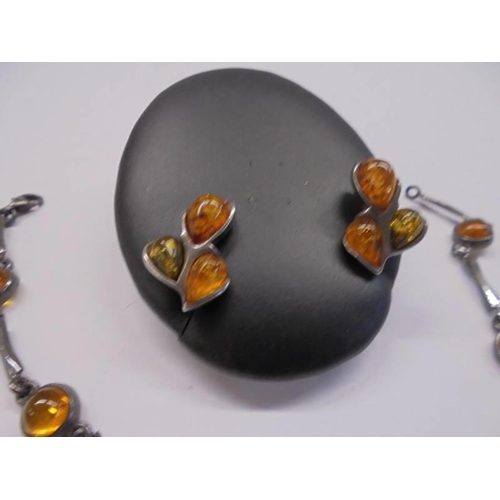 1086 - An amber set bracelet with matching amber ear studs set in silver.