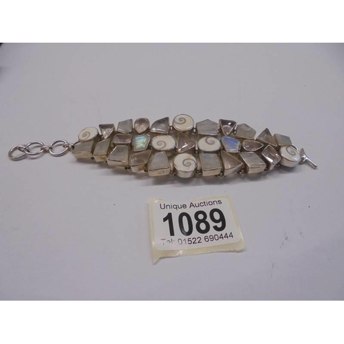 1089 - A heavy silver bracelet with various coloured stones.