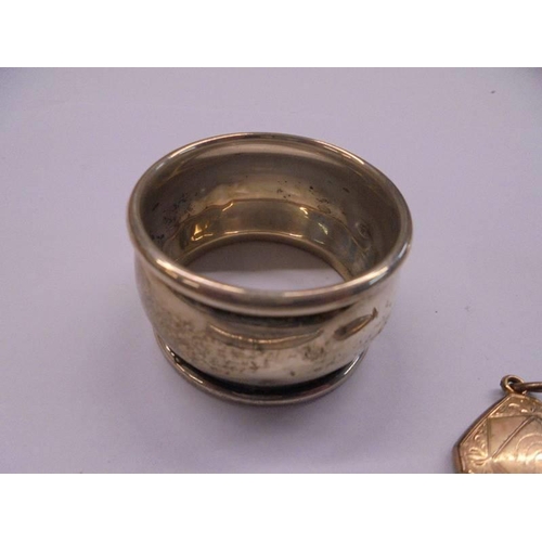 1100 - A silver napkin ring, silver pencil and yellow metal pendant.