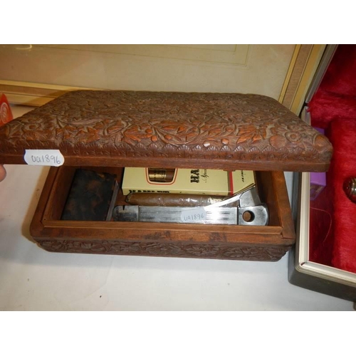 1639 - A heavily carved box containing cigar cutter and cigars.