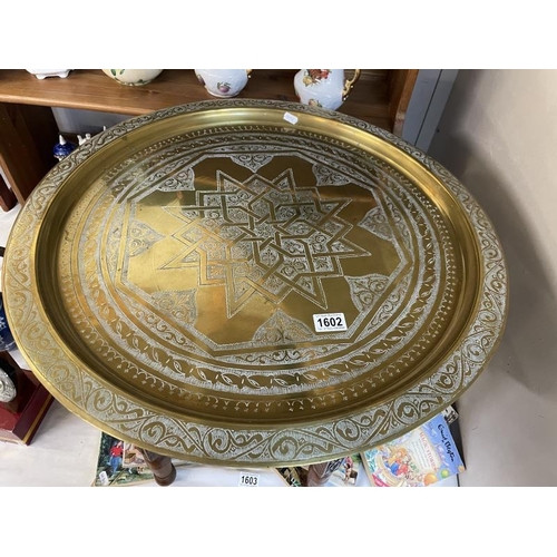 1602 - A Middle Eastern brass tray topped table