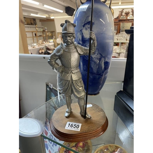 1650 - A spelter Knight in armour carrying a spear on wooden base