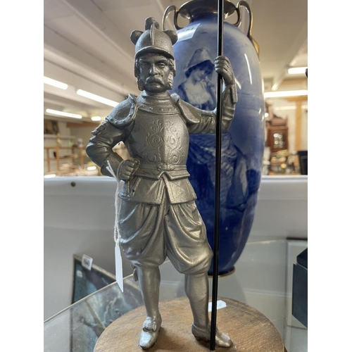 1650 - A spelter Knight in armour carrying a spear on wooden base