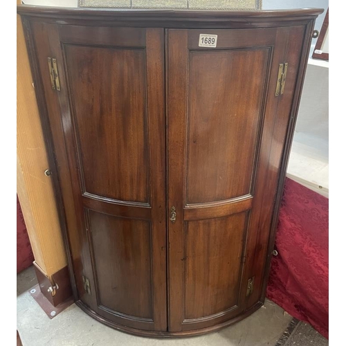 1689 - A mahogany bow fronted wall mounting corner cupboard, COLLECT ONLY.