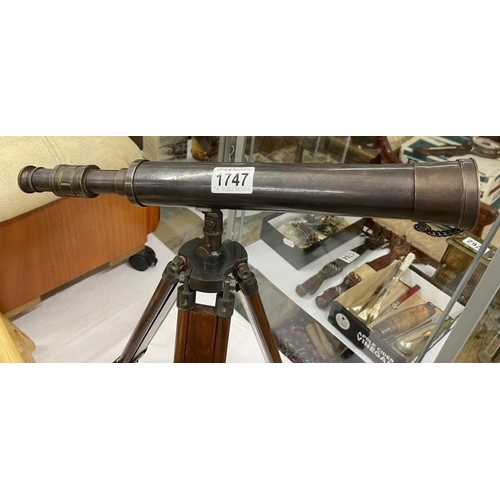 1747 - A bronzed telescope on wooden extending tripod