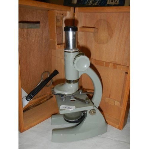 1411 - A cased student microscope.