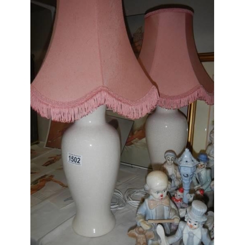 1502 - A pair of table lamps with pink shades.