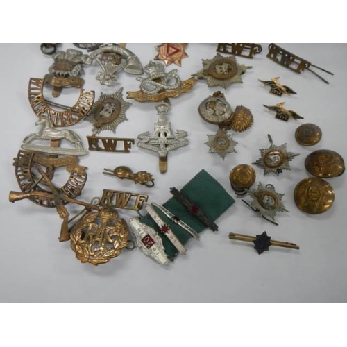 1582 - A quantity of military cap badges etc.,