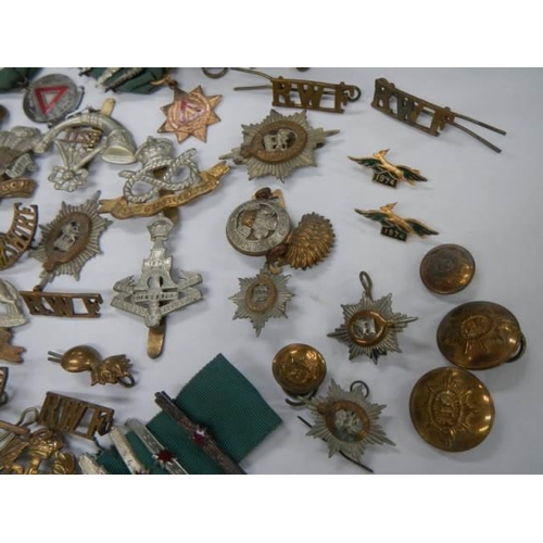 1582 - A quantity of military cap badges etc.,