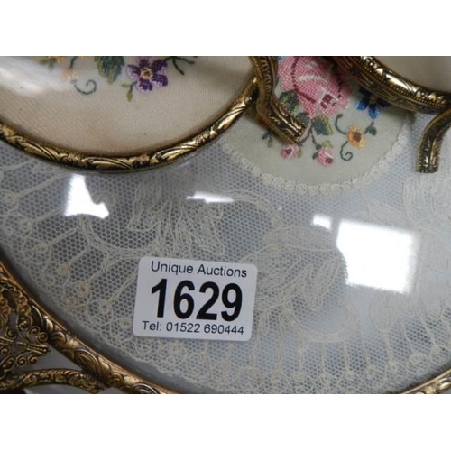 1629 - A vintage dressing table tray with lace inset and a pair of candlesticks.