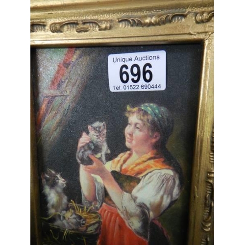 696 - A gilt framed overpainted print of a lady with kittens.