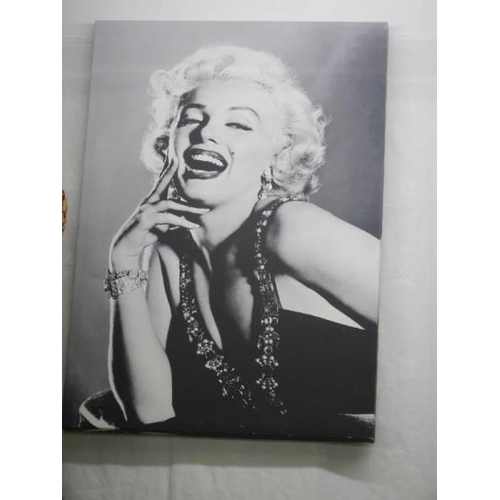 708 - A framed and glazed photograph of Marylin Monroe and one on canvas, COLLECT ONLY.