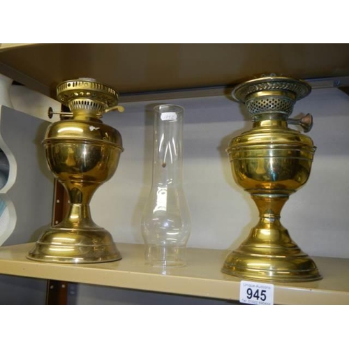 945 - Two old brass oil lamps.