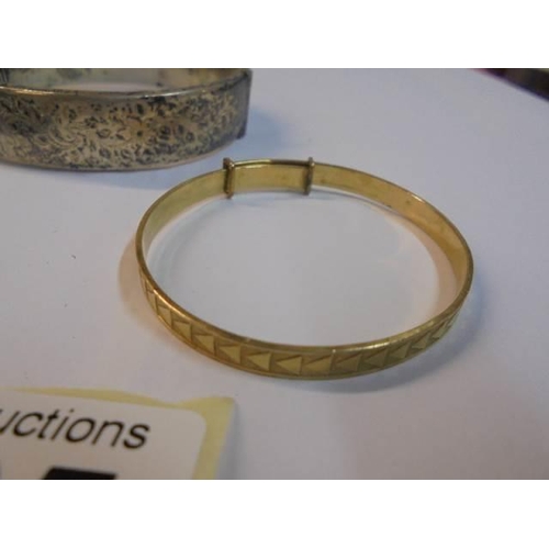 1065 - A silver bangle, a silver babies bangle and a gold plated babies bangle.