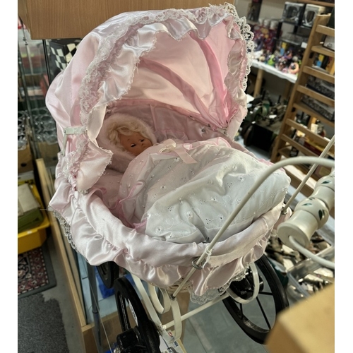 128 - A vintage wicker dolls pram with pink covering