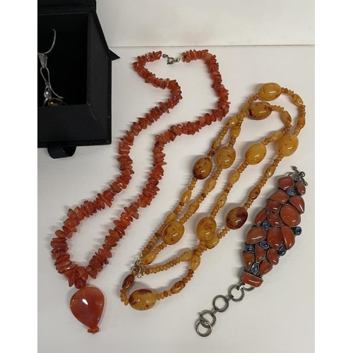 650 - Two Amber coloured necklaces, a pendant and a bracelet