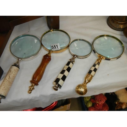 551 - Four assorted magnifying glasses.