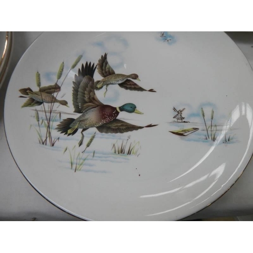 557 - In excess of 30 pieces of Ironstone tableware decorated with flying ducks. COLLECT ONLY.