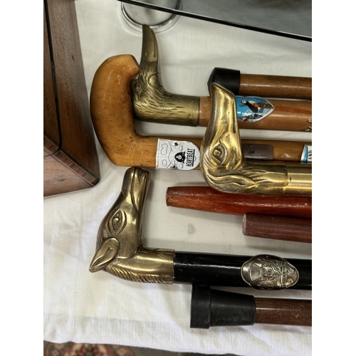 326 - A selection of walking sticks some with brass animal head handles & Tourist plaques