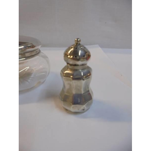 1141 - A silver pepperette, a silver topped scent bottle and a powder bowl with silver lid.