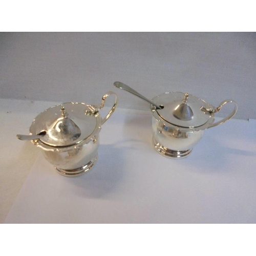 1153 - A pair of silver plate salts with spoons and blue glass liners and three others.