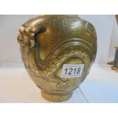 1218 - A Chinese bronze vase decorated with relief dragons, makers mark to bottom, 35 cm tall.