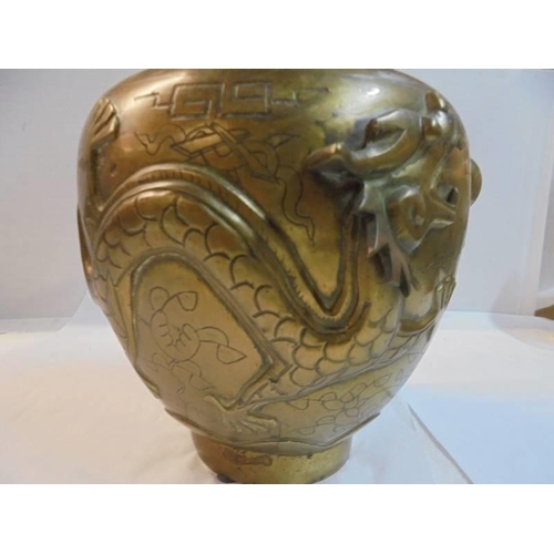 1218 - A Chinese bronze vase decorated with relief dragons, makers mark to bottom, 35 cm tall.