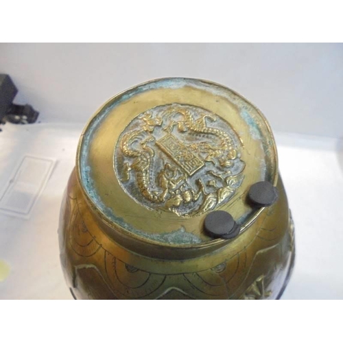 1218 - A Chinese bronze vase decorated with relief dragons, makers mark to bottom, 35 cm tall.