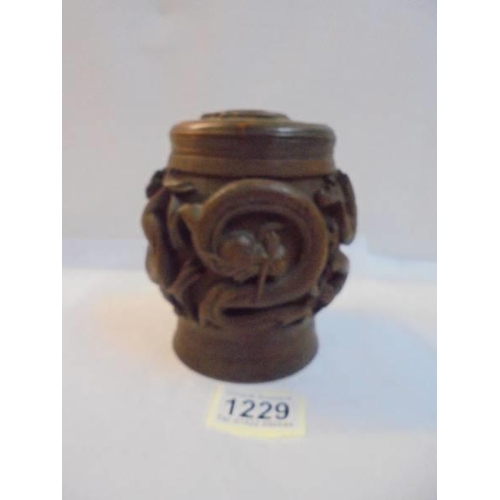 1229 - A Chinese carved wood tobacco jar, the lid having a regimental/royal crest.