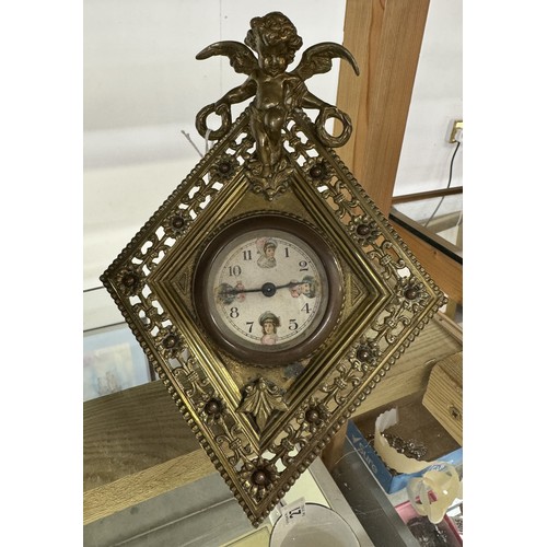 1131 - A brass diamond shaped cherub surmounted clock, circa 1900 by William Tonks, 21.5 cm tall.