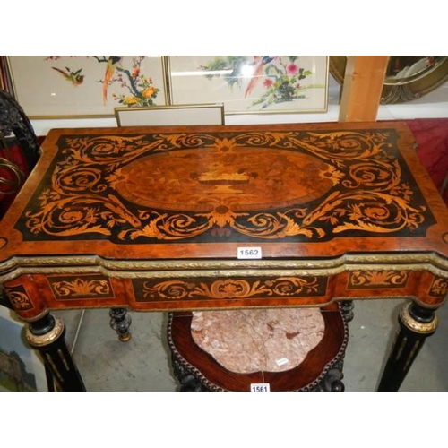 1562 - A Victorian marquetry inlaid fold over games table (felt need replacing), COLLECT ONLY.