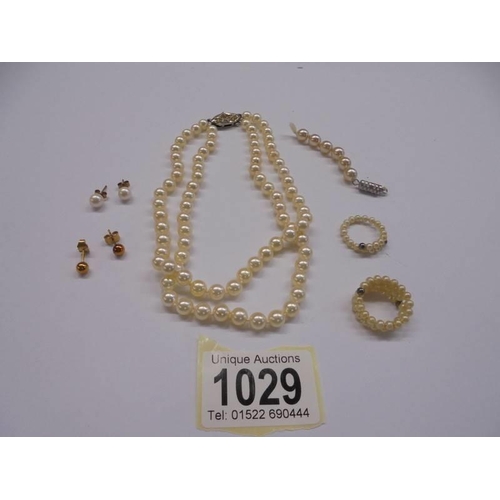 1029 - A pearl necklace, two pearl rings and two pairs of earrings.