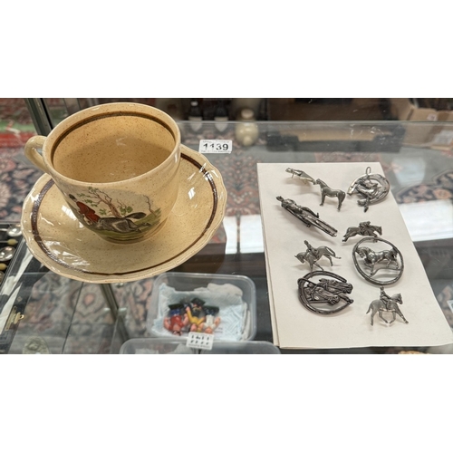 1139 - Some pewter equestrian brooches & A large Royal Worcester Palissy cup & saucer (Fox hunting themed)