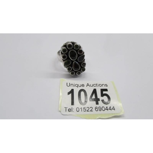 1045 - A multi stone set heavy silver ring in an oval shape, size R, 14.36 grams.