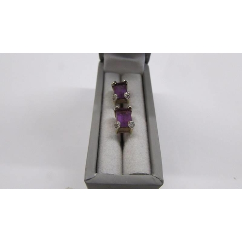 1055 - A pair of amethyst stud earrings in 9ct gold.