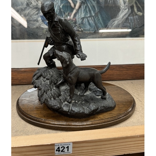 421 - A bronze effect figure of a gamekeeper with dog.