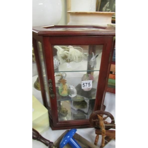 575 - A small glazed cabinet and contents.