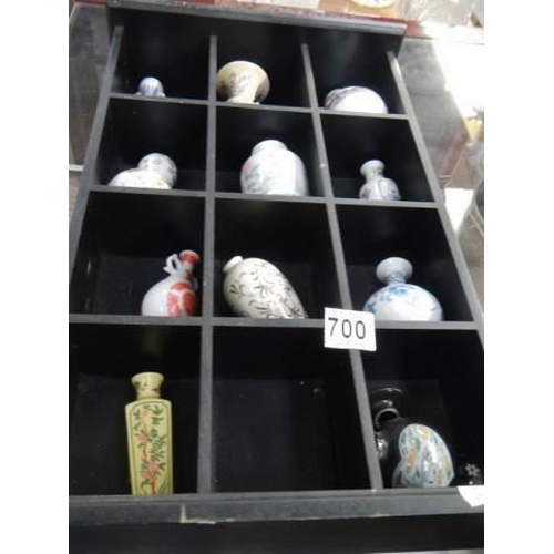 700 - A small display case with eleven minaiture Chinese style vases.