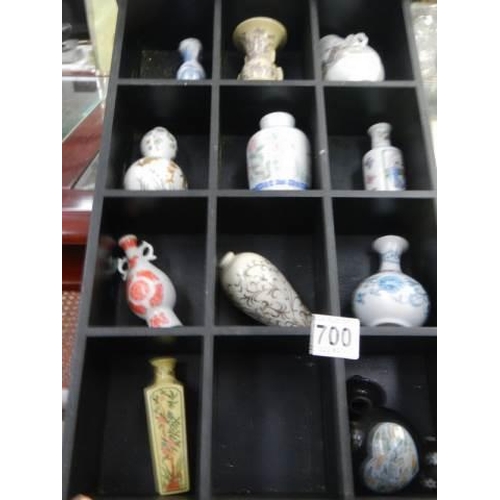 700 - A small display case with eleven minaiture Chinese style vases.