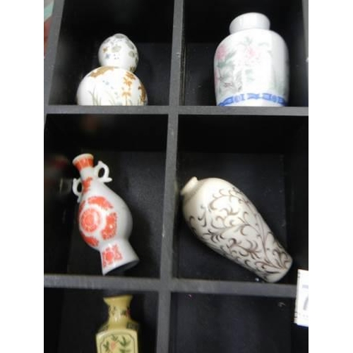 700 - A small display case with eleven minaiture Chinese style vases.