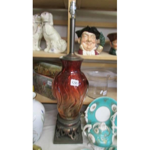 1295 - A tall red glass table lamp on metal base, will need re-wiring, COLLECT ONLY.