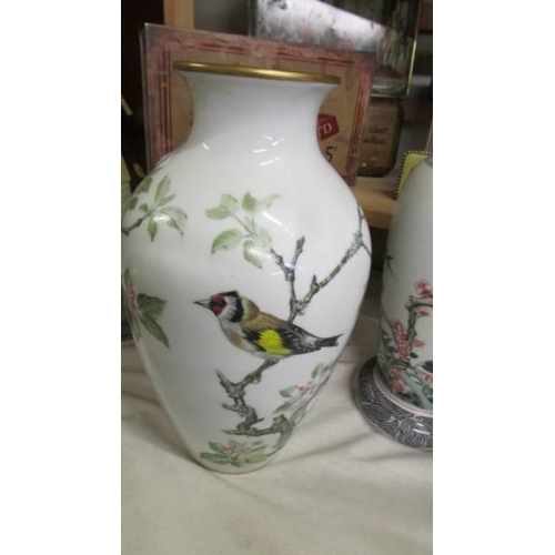 1300 - A pair of vases and one other all hand painted with birds.