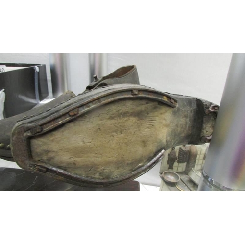 1339 - A pair of early 20th century shoes with wood and metal horse shoe shape soles and leather tops.