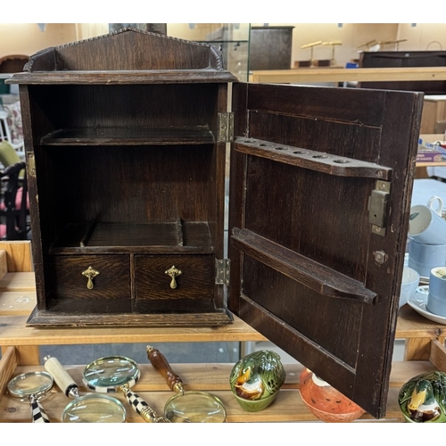 89 - An oak smokers cabinet with native Indian head carving to door