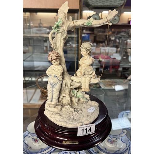 114 - A decorative table lamp with children on a swing by Florence