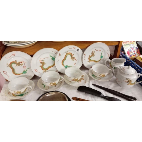 355 - A rea set with dragon design including 4 plates, 4cups & saucers, milk jug & sugar pot