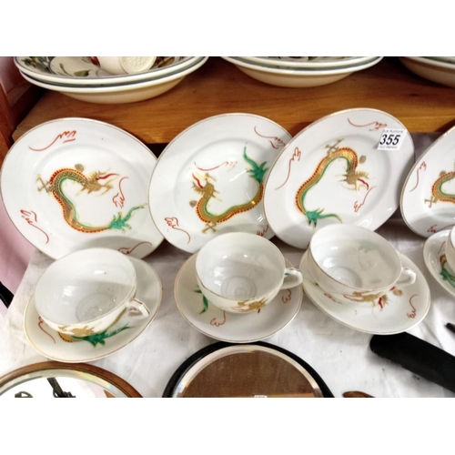 355 - A rea set with dragon design including 4 plates, 4cups & saucers, milk jug & sugar pot