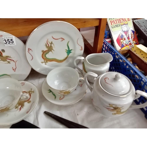 355 - A rea set with dragon design including 4 plates, 4cups & saucers, milk jug & sugar pot