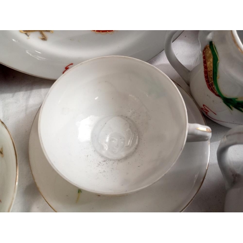 355 - A rea set with dragon design including 4 plates, 4cups & saucers, milk jug & sugar pot